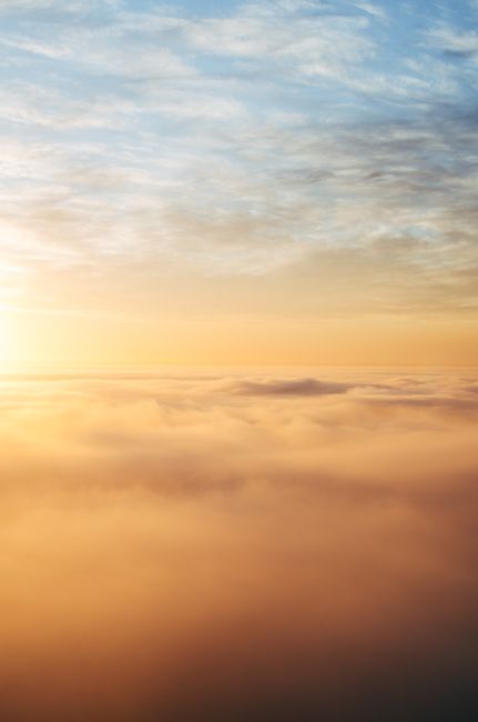 Dramatic golden hour sky with stunning layered clouds captured from above.