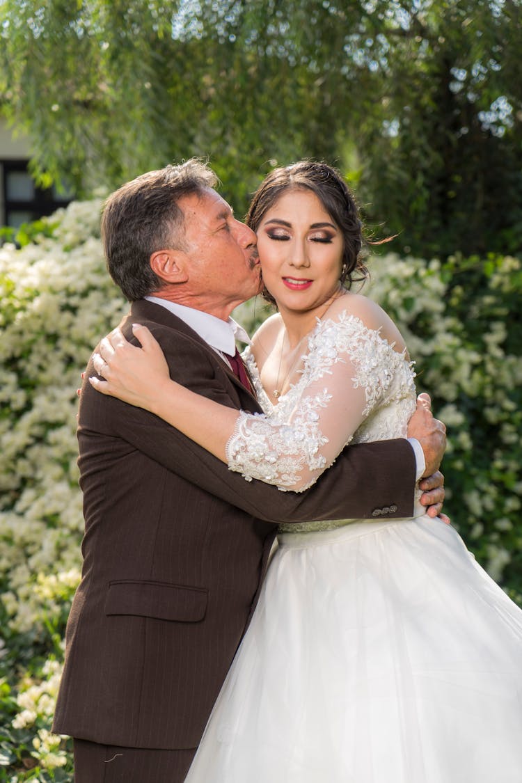 Father Kissing His Daughter On The Cheek On Her Wedding Day 