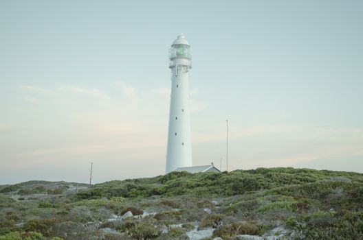 A serene view of Slangkop Lighthouse in Cape Town, providing guidance against a clear sky.