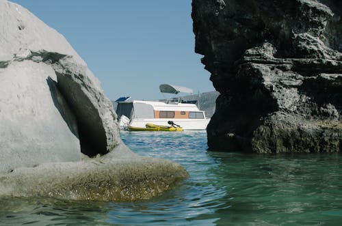 Ship Sailing in a Bay Between Cliffs and Rock Formations