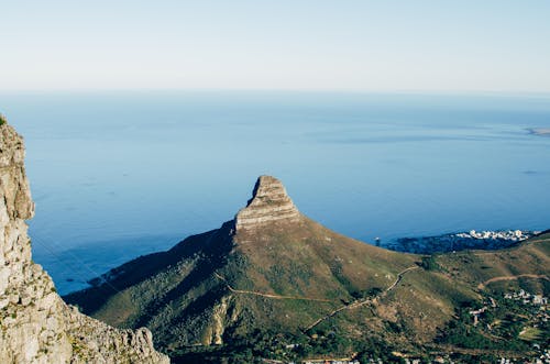 Green and Brown Mountain Beside Blue Sea