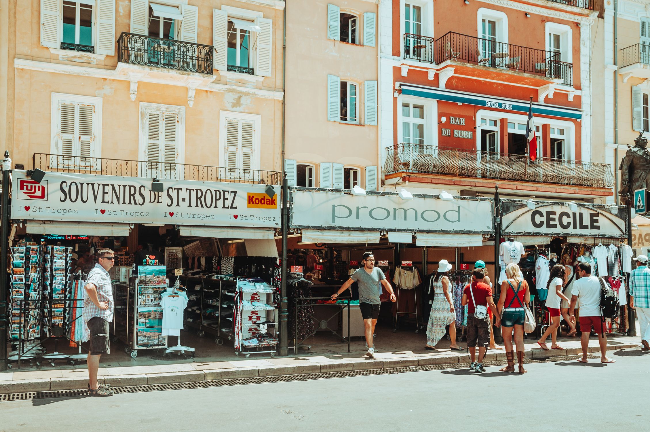 Charming street in St. Tropez filled with souvenir shops and tourists exploring the local stores.