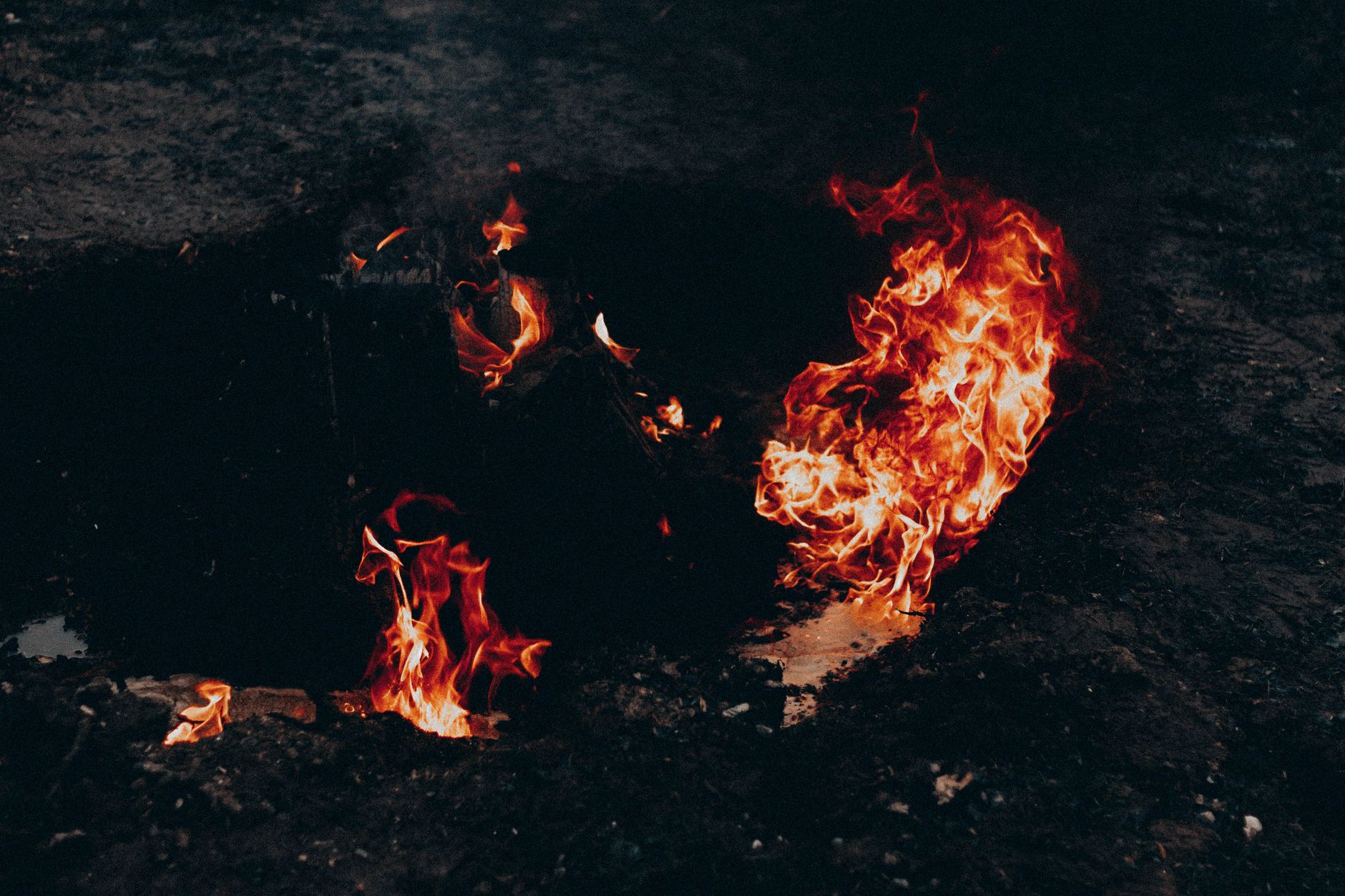 High angle of bright flame forming waves in air above dark land at dusk — photo by Mathias Reding / Pexels