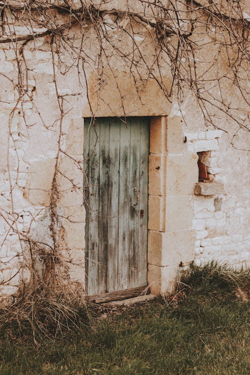 Old house with wooden door in countryside in autumn