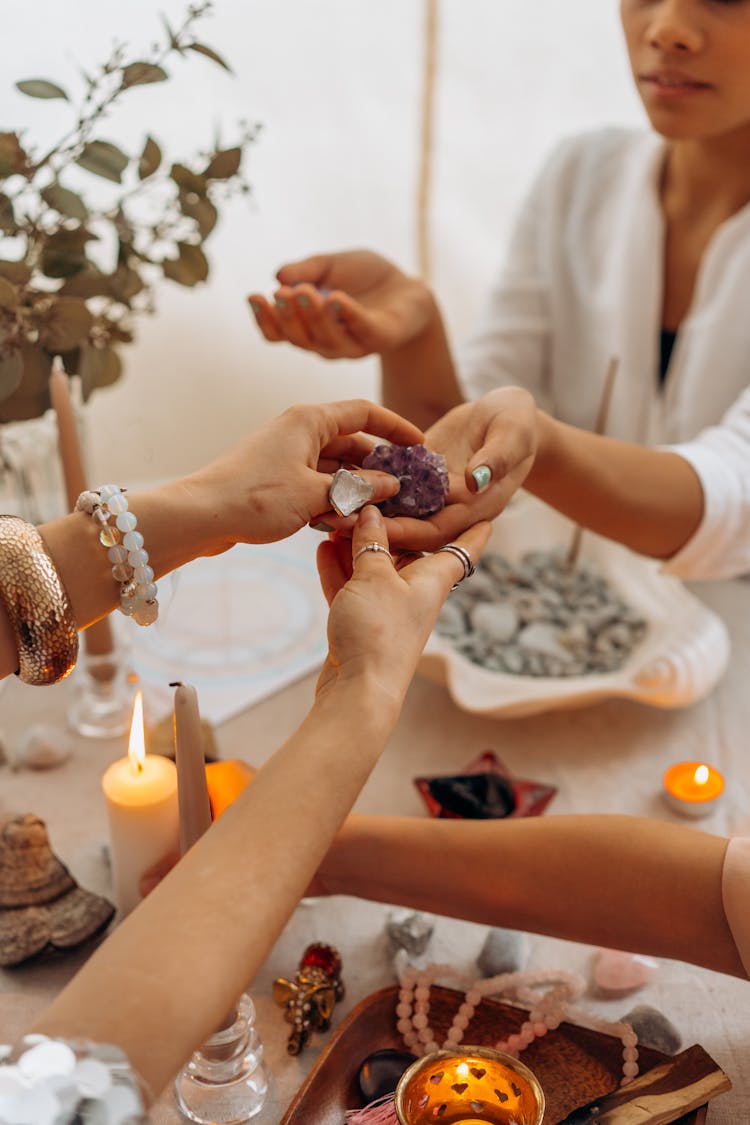 A Person Handing A Stone To A Woman