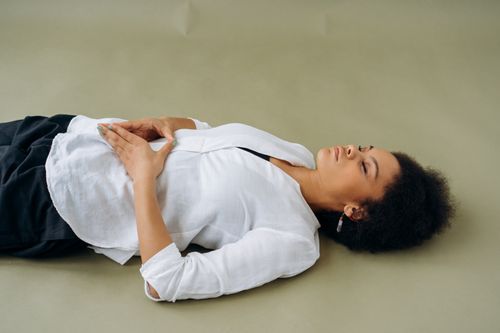 Free African American woman lying down with eyes closed, embodying relaxation and wellness. Perfect for wellness and mindfulness themes. Stock Photo