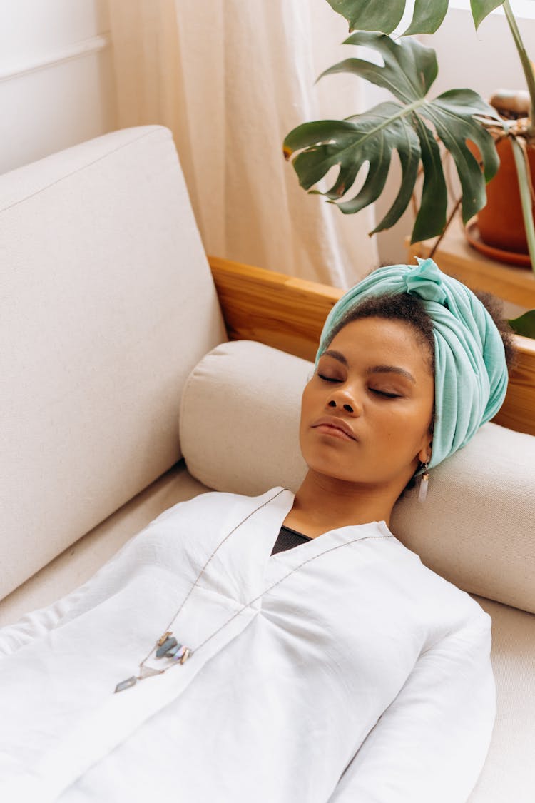 Woman Wearing Blue Headscarf Sleeping On A Couch