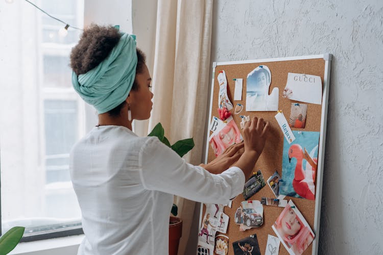 Woman In Blue Headscarf Posting Note On The Board