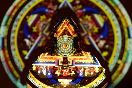 Woman Standing in front of a Colorful Projection while Looking Up