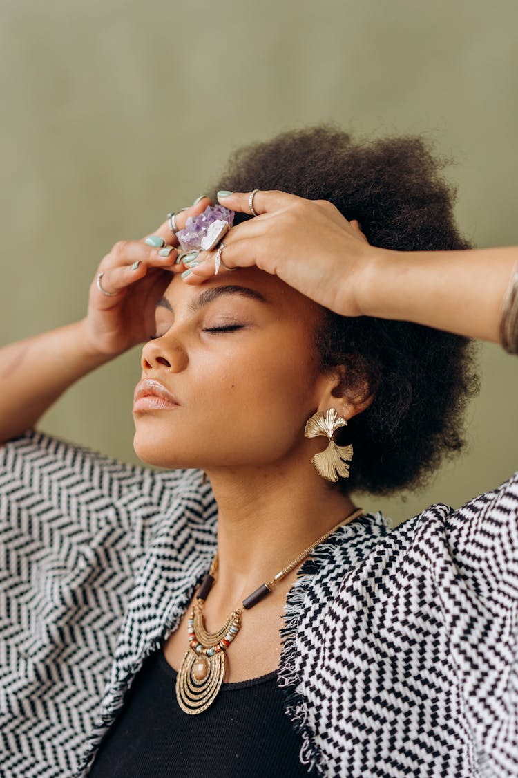 A Woman Putting The Amethyst Gemstone On Her Forehead