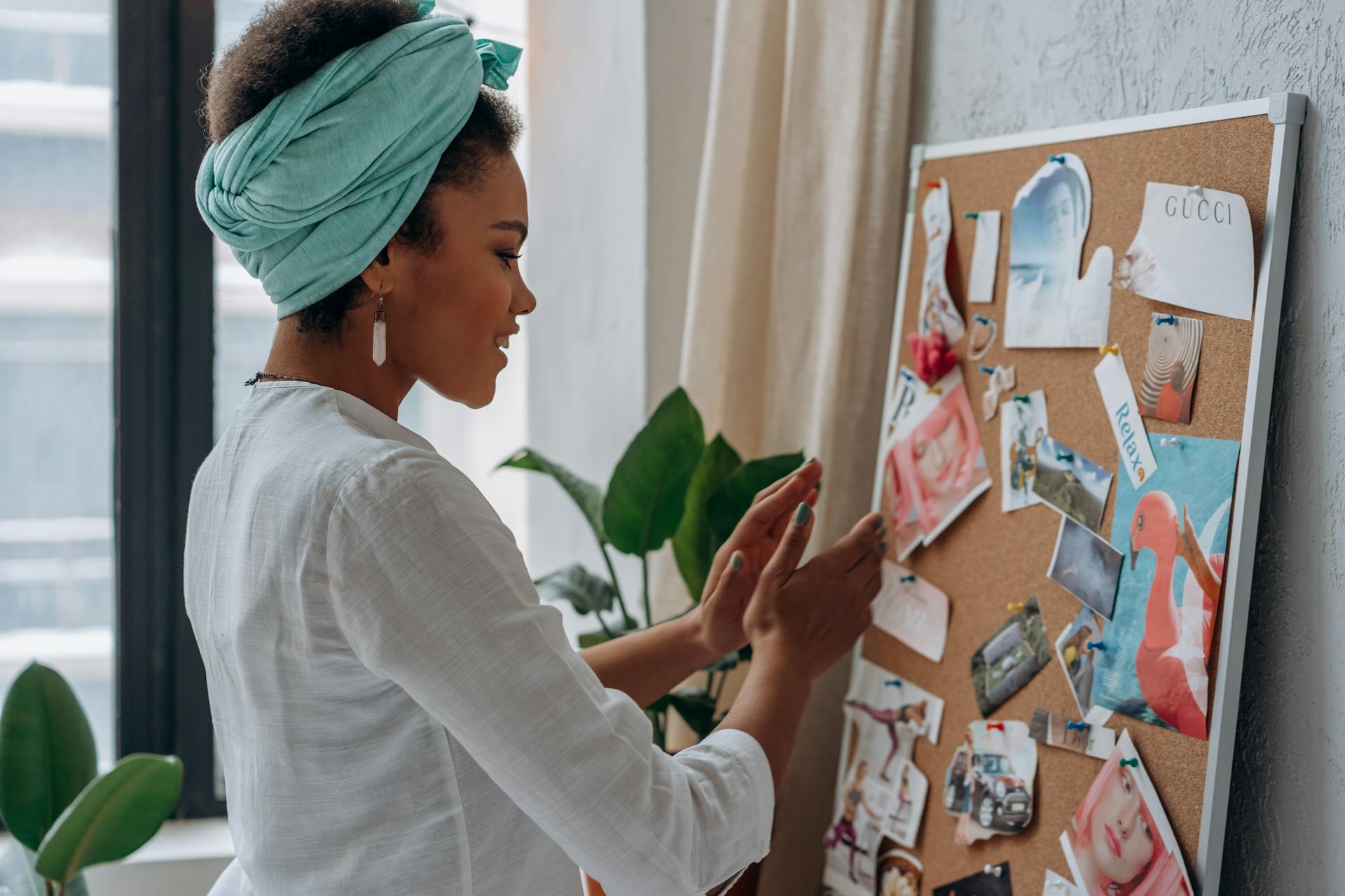 A Woman Wearing Blue Headscarf Looking at the Notes on aa Cork Board