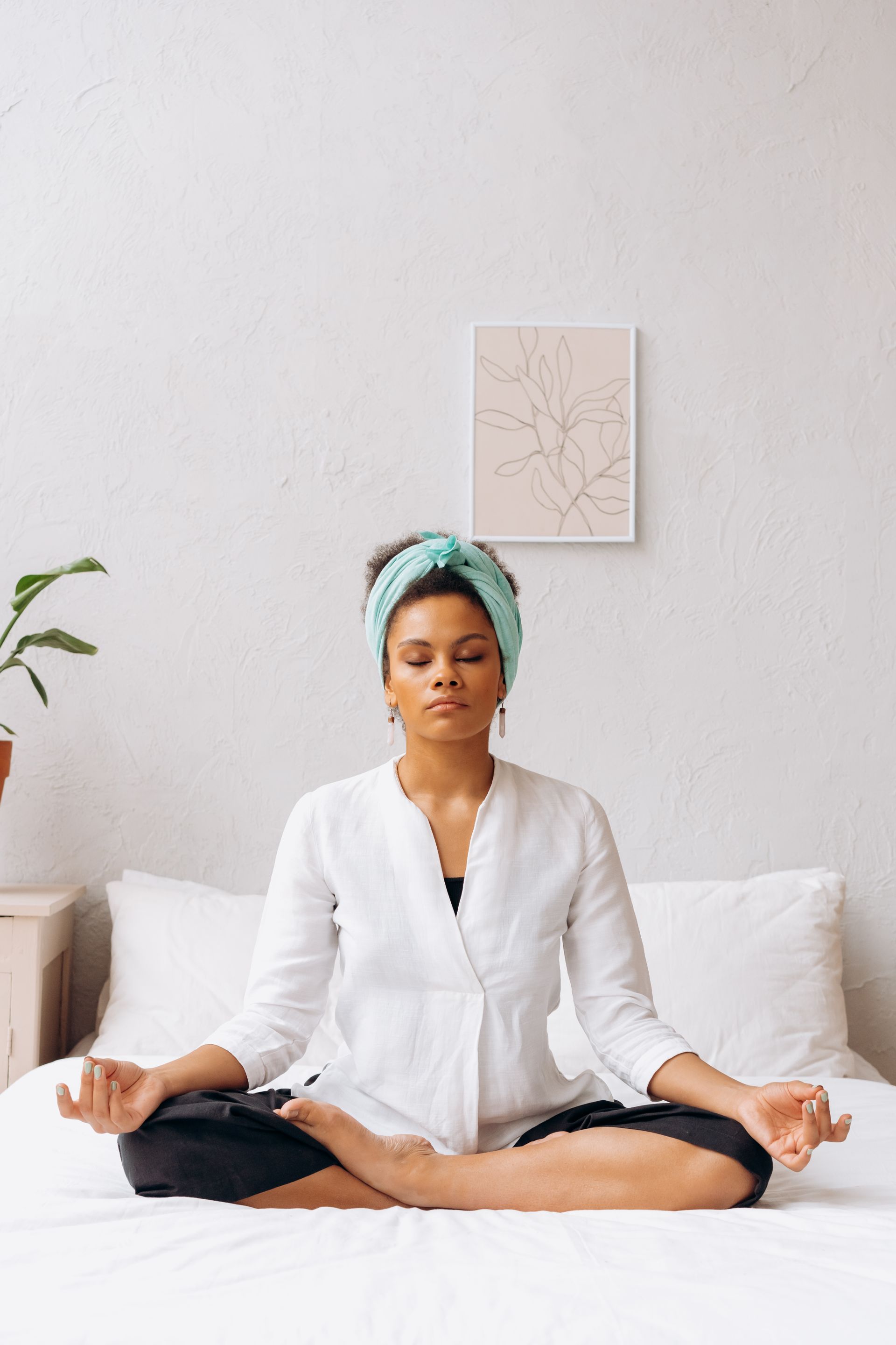 A mother meditating peacefully in a bright white room