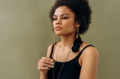 Free Elegant portrait of a woman with afro hair in a contemplative pose, exuding calm and relaxation. Stock Photo