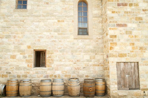 Wooden Barrels Beside Shingle Wall