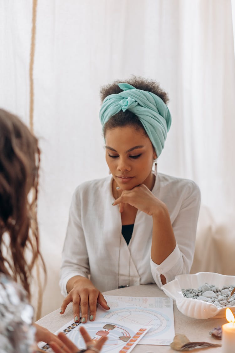 A Psychic Woman Sitting At A Table