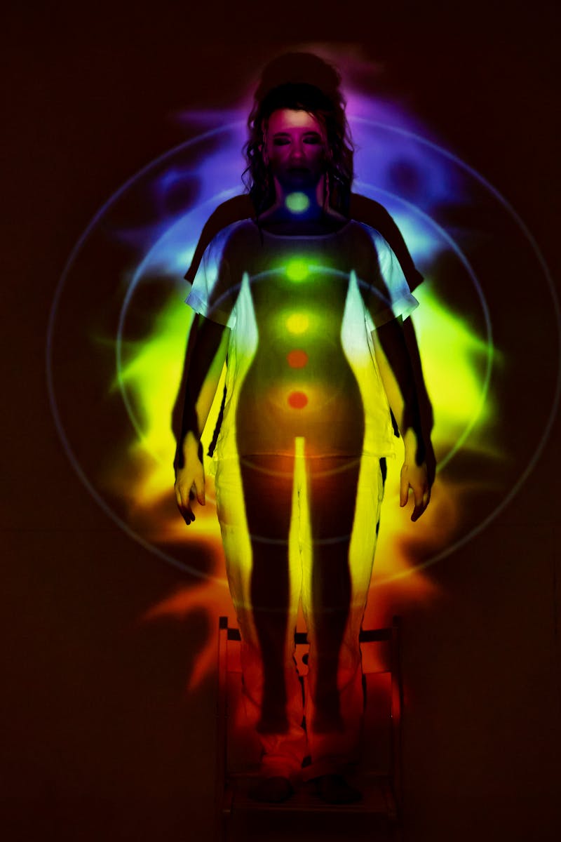 Human silhouette with vibrant chakra energy projection, symbolizing balance and spirituality.