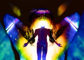 A silhouette emerges through colorful projections, evoking spirituality and energy.