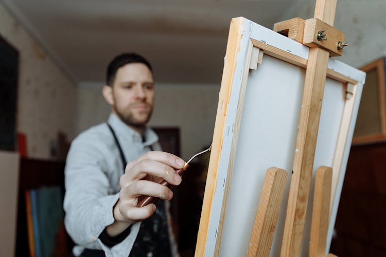 A Man Painting On A Canvas