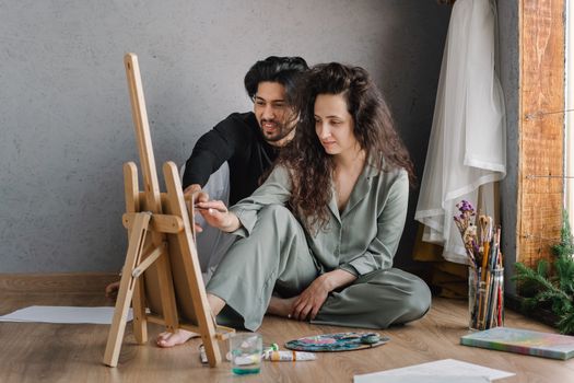 Couple painting at home, showcasing artistic collaboration and creativity in a relaxed setting.
