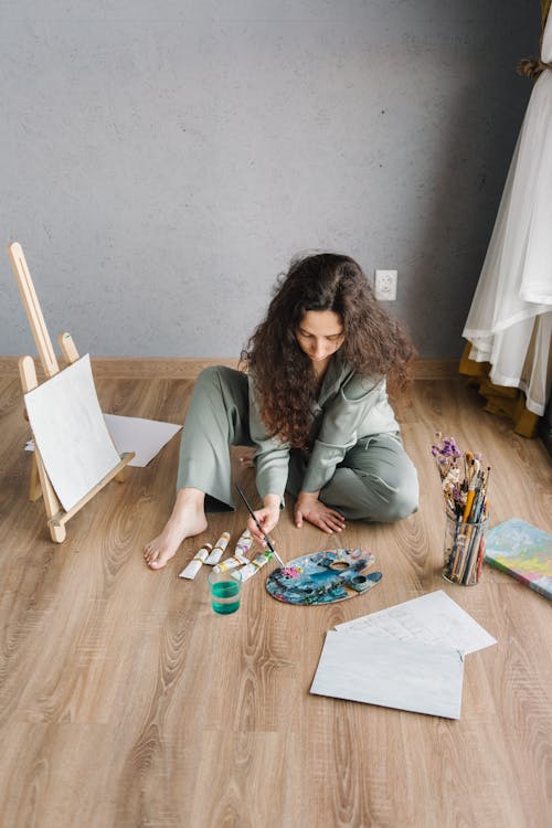 Woman Putting Paint on Paintbrush