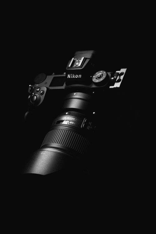 Free Monochrome close-up of a DSLR camera lens in low light setting. Stock Photo