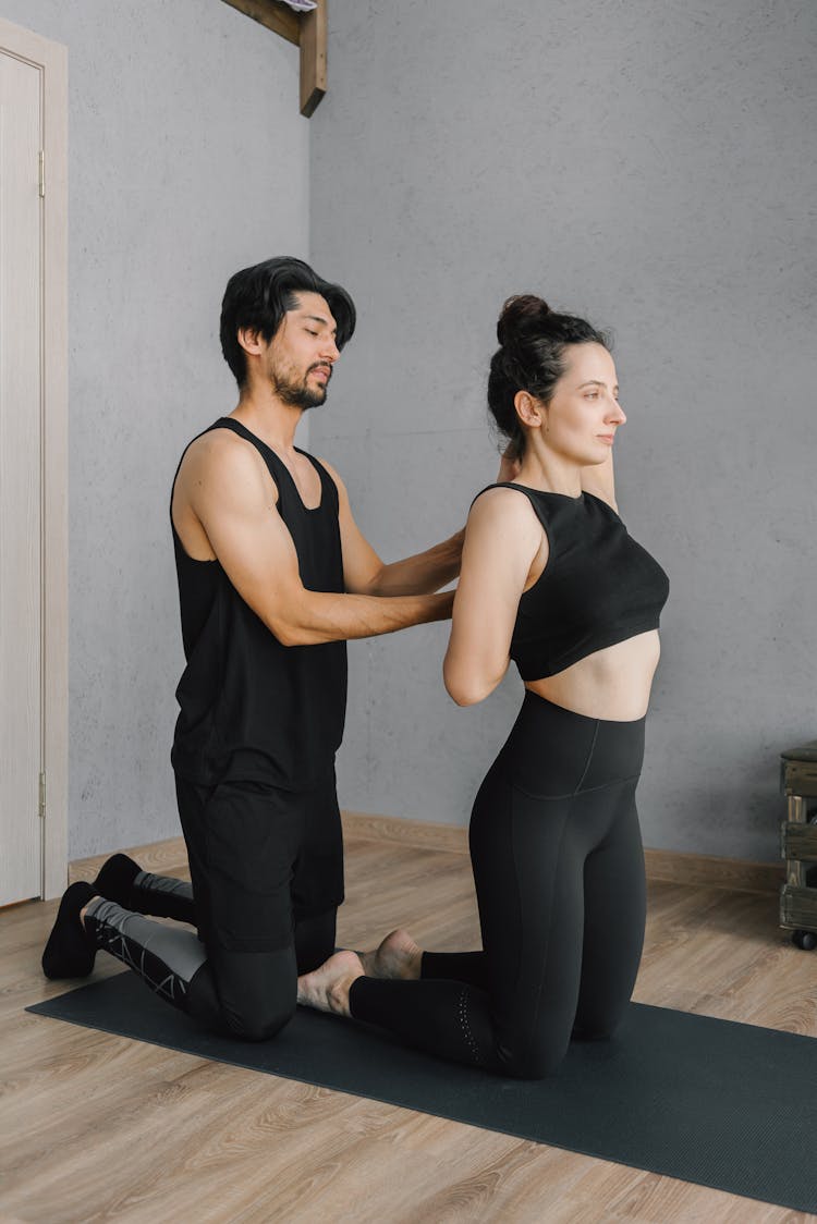 Photo Of Man Assisting A Woman Stretching Her Arms