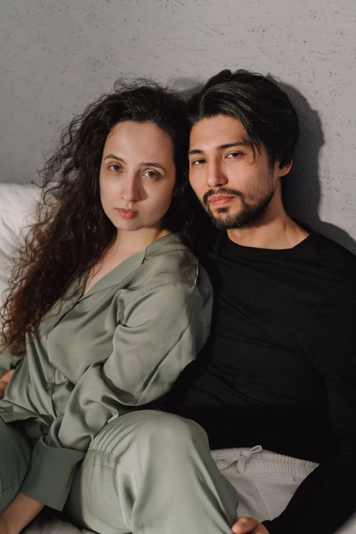 Free A cozy portrait of a couple sitting together, exuding warmth and connection. Stock Photo
