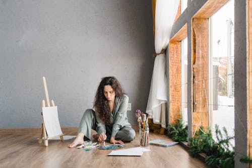 Woman Sitting On The Floor While Painting