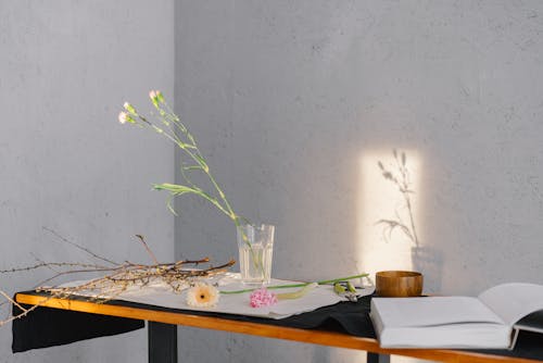 Flowers Beside an Open Book over a Table 