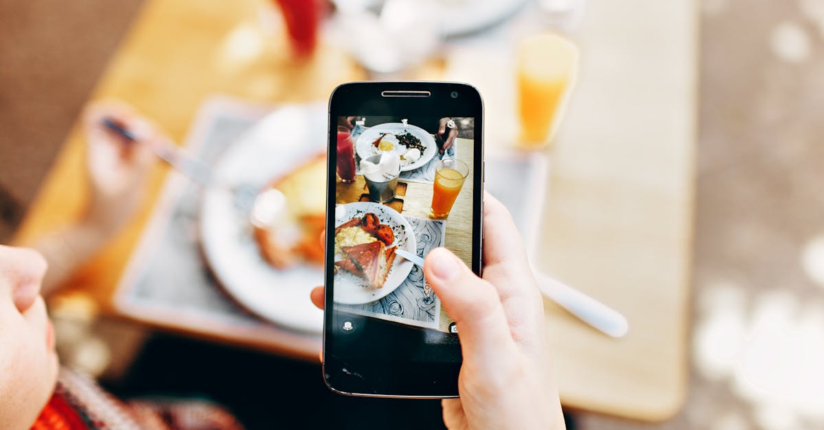 Person Holding Phone Taking Picture of Served Food