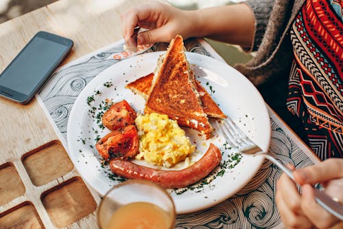 Free Toaster Bread, Scrambled Eggs, Grilled Tomato and Sausage Stock Photo