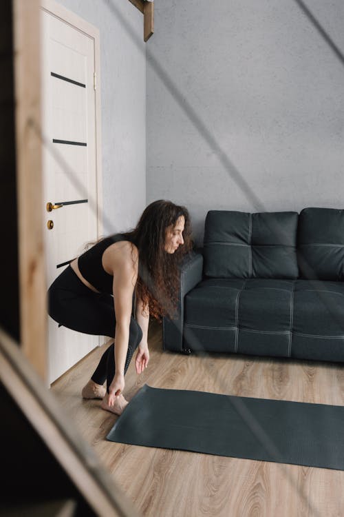 Photograph of a Woman Setting Up Her Yoga Mat