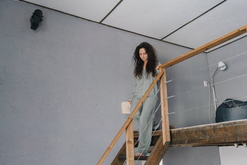 Woman Wearing Pajamas Walking Down the stairs