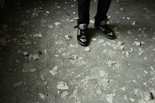 Person Standing on Gray Concrete Pavement Wearing Black-and-gray Lace-up Sneakers