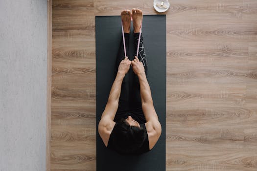 Top view of a man stretching on a yoga mat with a resistance band, promoting fitness and health.