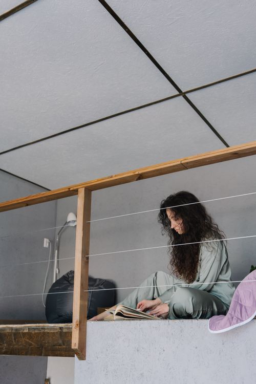 Free Caucasian woman in pajamas reading indoors, creating a cozy and serene atmosphere. Stock Photo