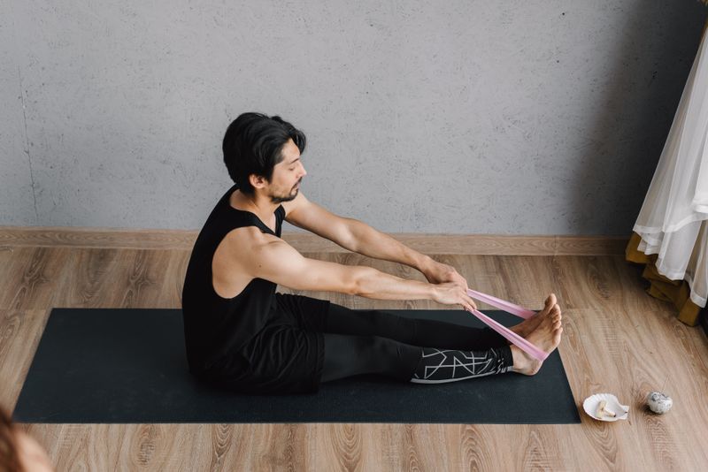 Seated forward stretch on a mat, by Mikhail Nilov on Pexels