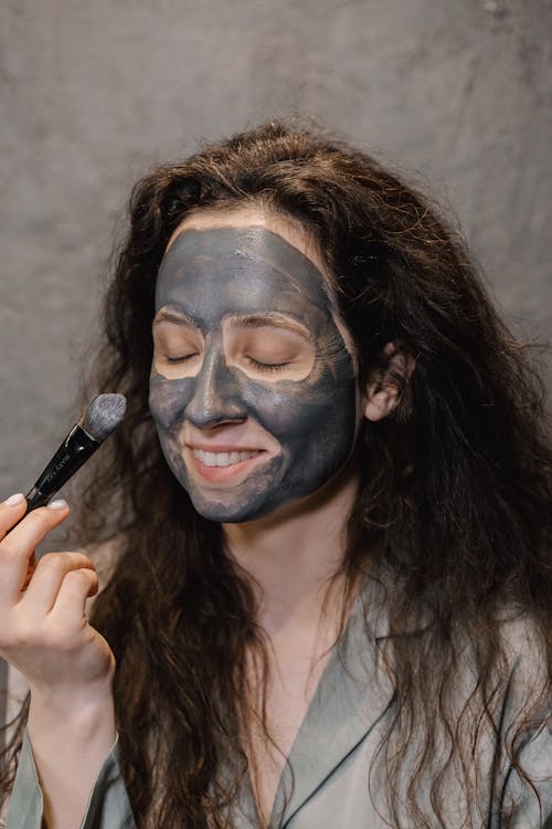 A Woman Applying Clay Mask on Her Face