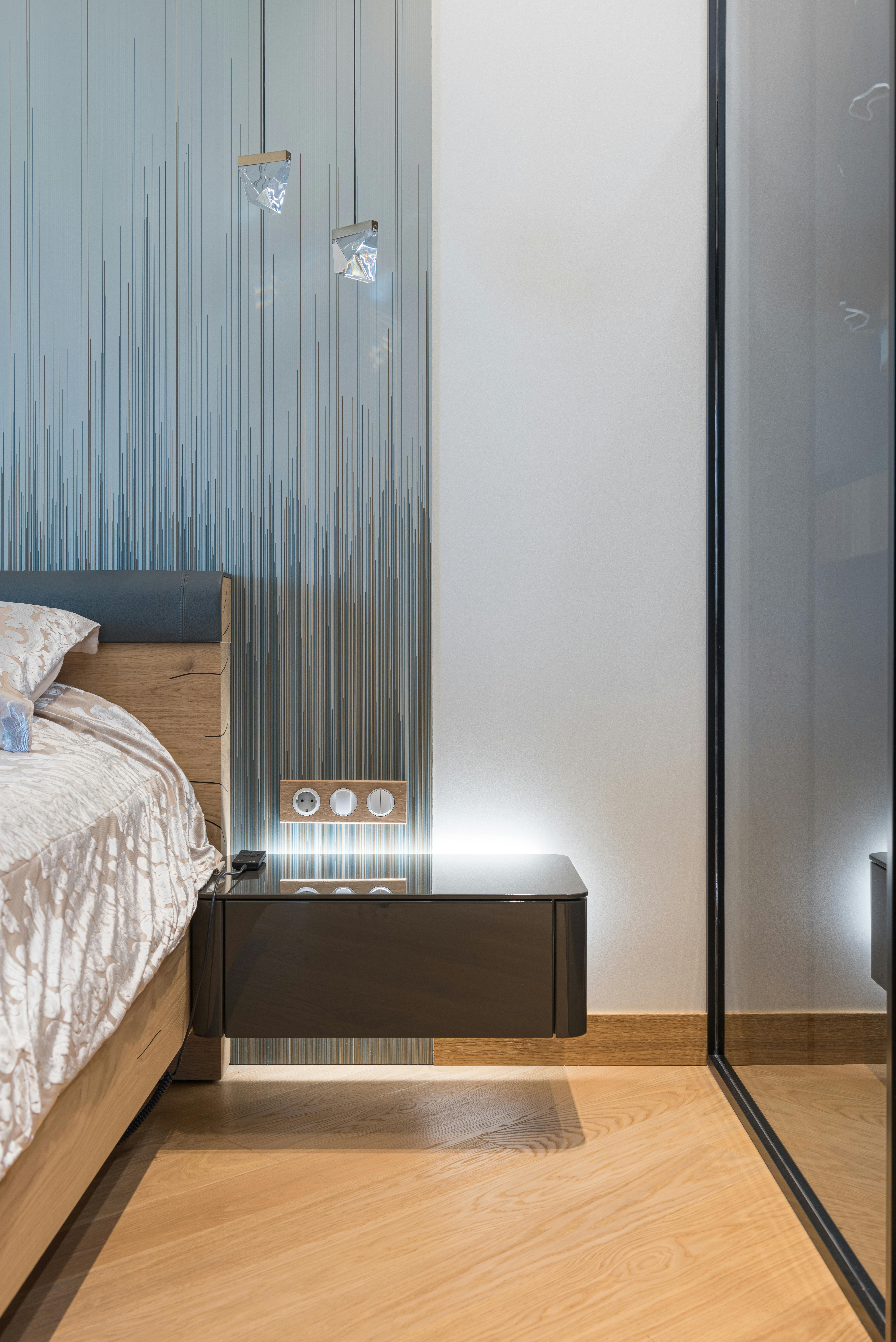 interior details of contemporary bedroom with bedside table and wardrobe