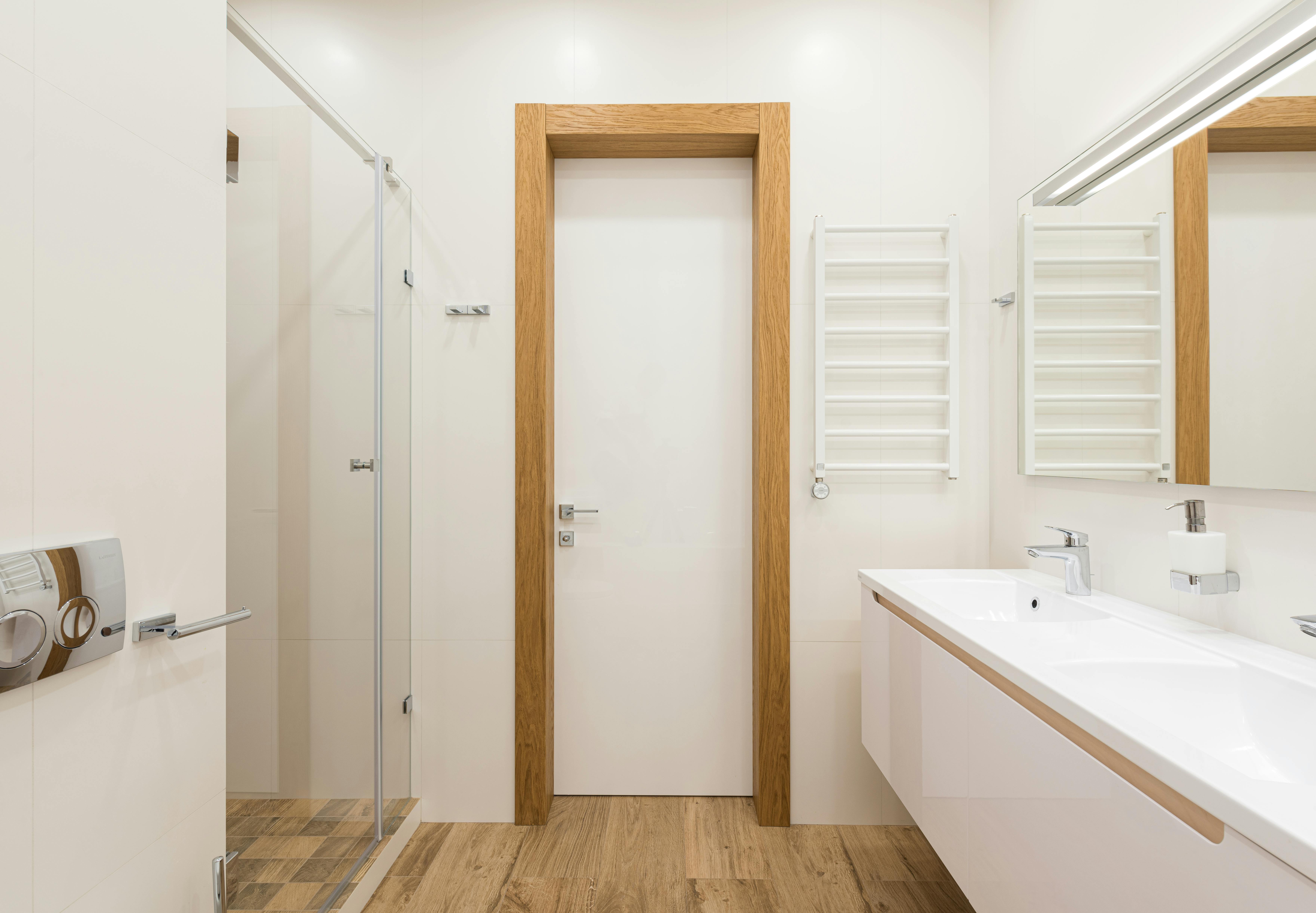 stylish interior of bathroom with shower cabin and white cupboard