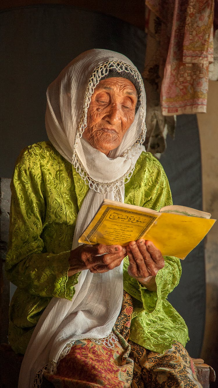 Senior Indian Woman In Headscarf Reading Book