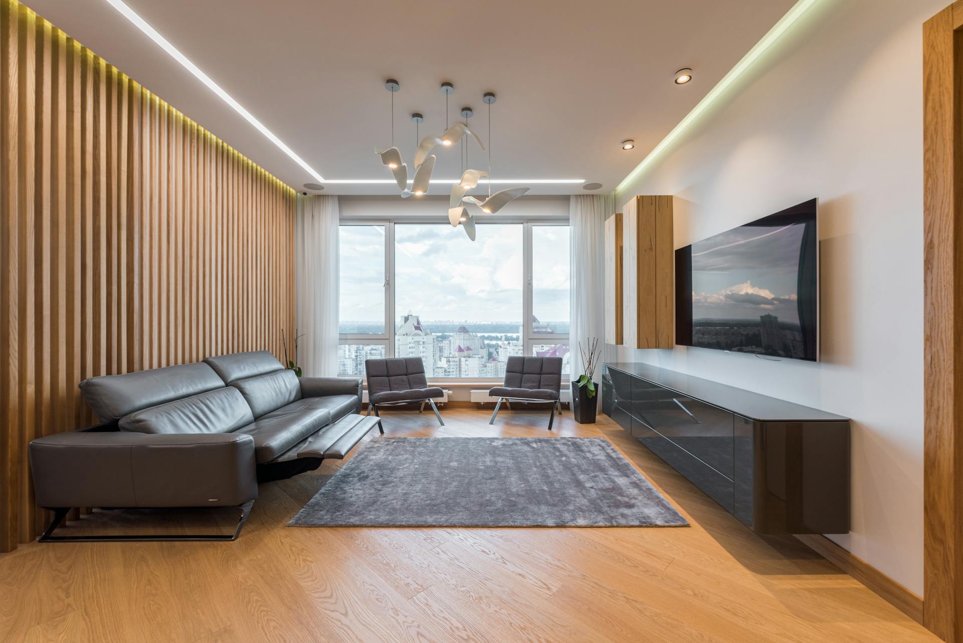 Modern spacious interior of lounge with TV and leather sofa