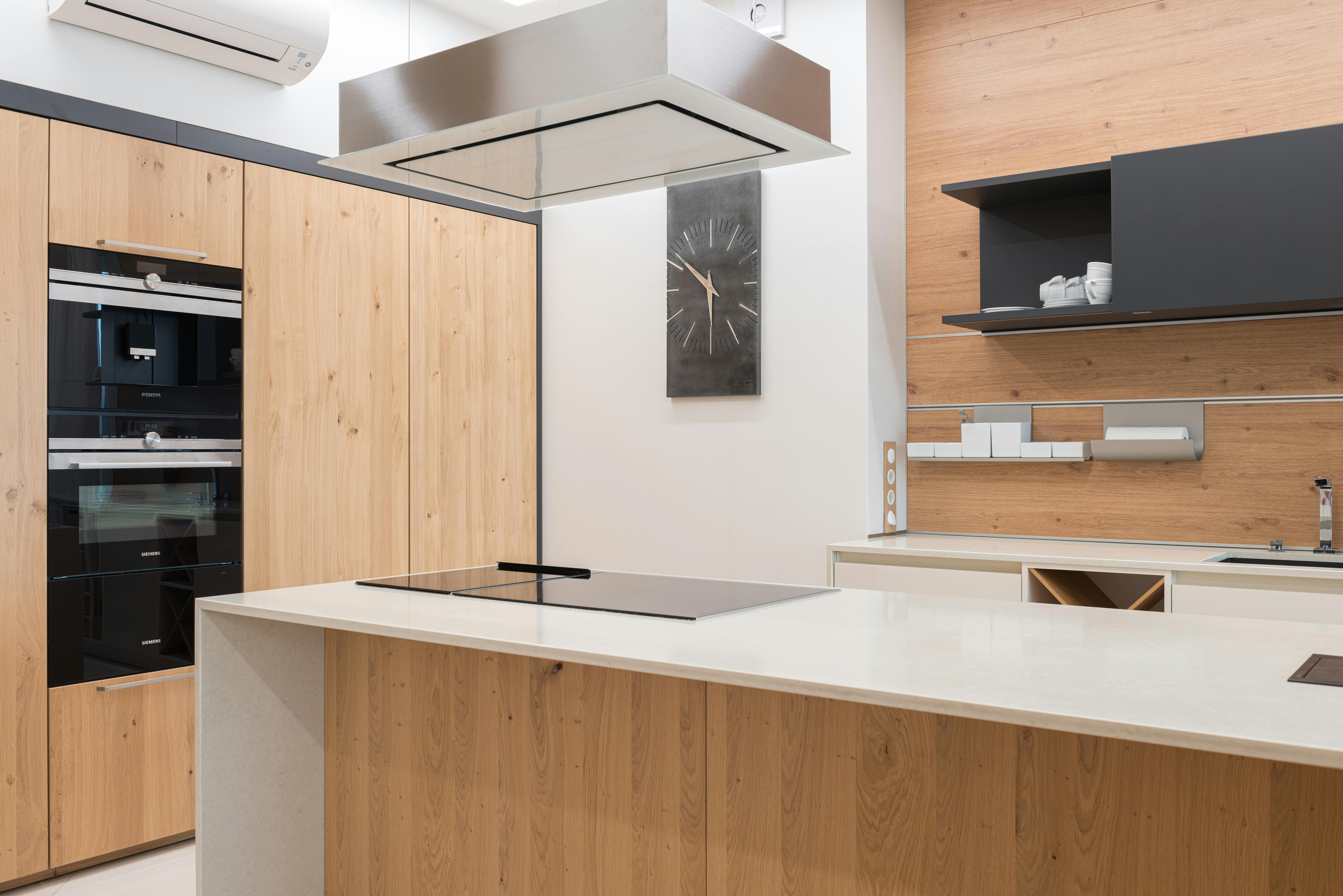 contemporary kitchen with black clock and cupboard with white utensil