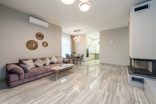 Large contemporary flat with cozy large sofa in front of electric fireplace and table with chair in dining room