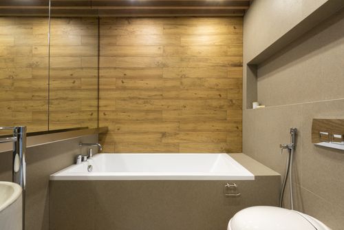 Free Interior of modern bathroom with mirror hanging above sink and bathtub near toilet and bidet spray Stock Photo