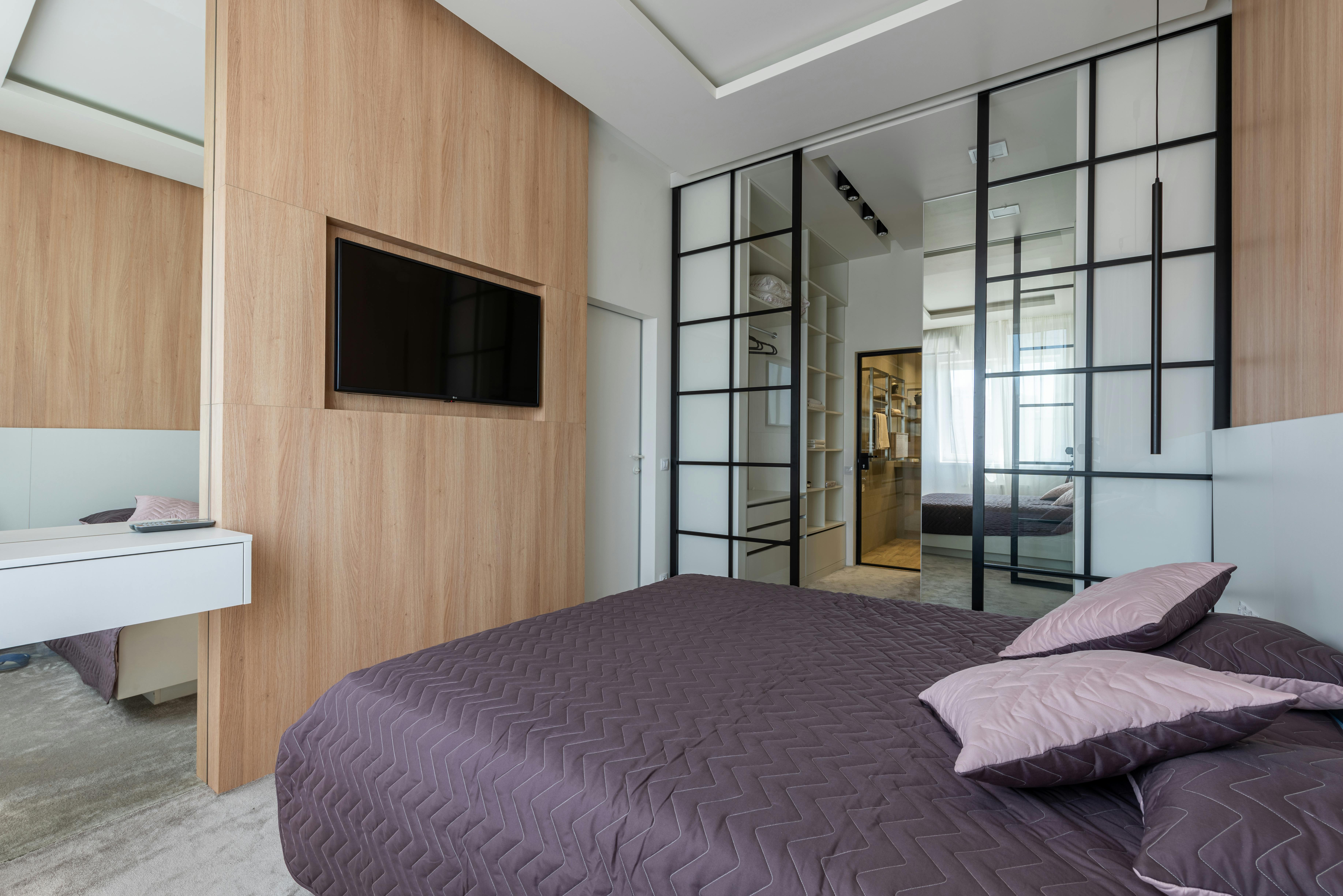 bed with tv set on wall in bedroom