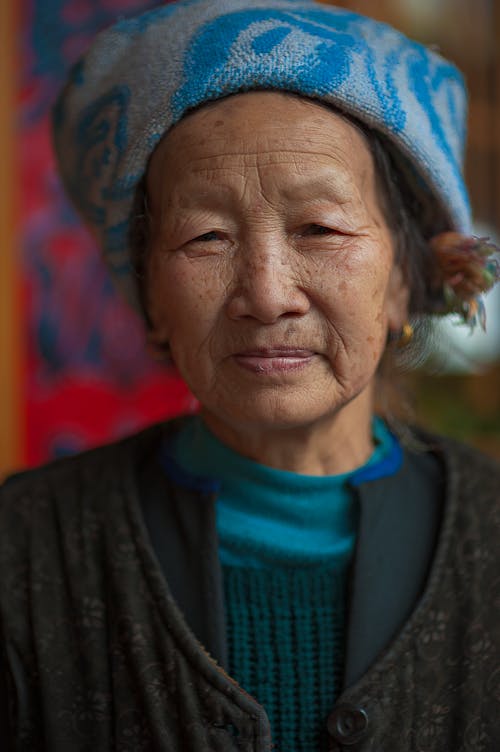 Smiling senior Asian woman in headwear with ornament