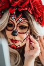 A Woman with Face Paint on Her Face Putting Make-up on Her Face