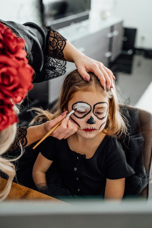 Person Applying Art Makeup On a Girl