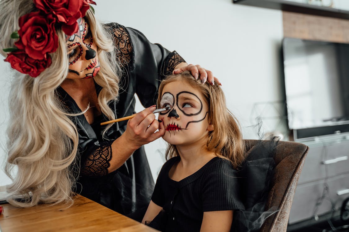 Free Woman in Black Dress Applying Makeup On A Girl Stock Photo